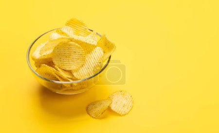 Photo for Bowl of chips on a yellow background with copy space - Royalty Free Image
