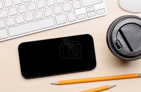 Foto de Smartphone de pantalla negra en blanco en un escritorio, perfecto para su maqueta de diseño - Imagen libre de derechos