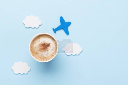 Téléchargez les photos : Concept de voyage et vacances. Café et avion sur bureau bleu avec espace de copie - en image libre de droit