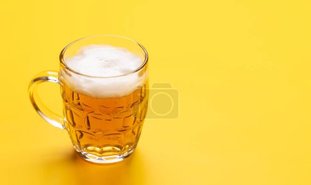 Téléchargez les photos : Une bière froide sur un fond jaune vif avec espace de copie - en image libre de droit