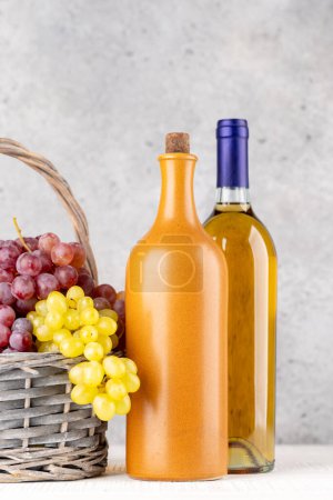 Photo for Ripe grape in basket and wine bottles. With copy space - Royalty Free Image
