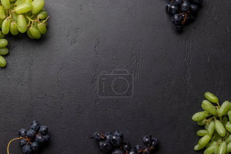 Téléchargez les photos : Une vue de dessus de divers raisins sur une table en pierre, avec beaucoup d'espace ouvert pour le texte. Pose plate - en image libre de droit