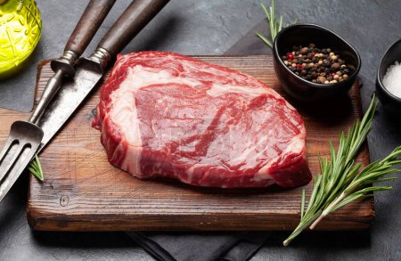 Foto de Raw ribeye steak on cutting board. Barbecue cooking - Imagen libre de derechos