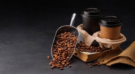 Foto de Rico café para llevar en una taza de papel y granos tostados aromáticos, un brebaje matutino perfecto - Imagen libre de derechos