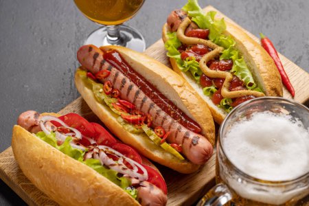 Foto de Various hot dog and beer. Homemade hotdogs on cutting board - Imagen libre de derechos