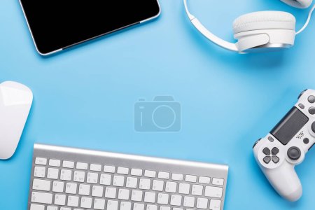 Photo for Gaming gear and tech accessories on a blue background, perfect for gaming and tech-related themes. Flat lay with copy space - Royalty Free Image