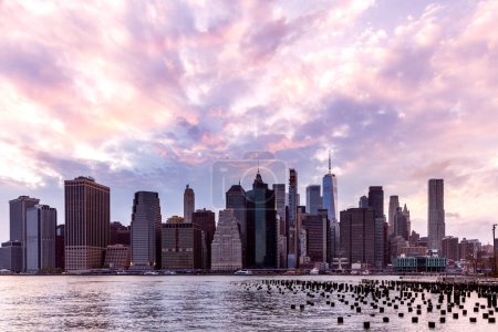 Téléchargez les photos : Manhattan skyline à New York en face de la rivière, mettant en valeur l'architecture impressionnante et le paysage urbain moderne au coucher du soleil - en image libre de droit