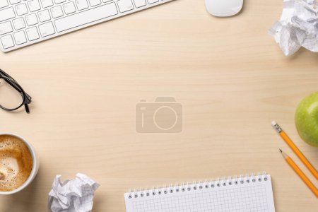 Téléchargez les photos : Vue du dessus du bloc-notes vierge, du clavier, de la tasse à café, des lunettes et des papiers froissés sur le bureau, représentant des tentatives infructueuses d'écriture - en image libre de droit
