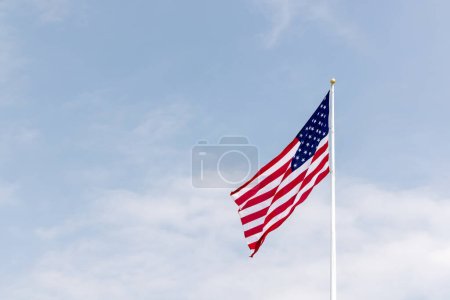 Foto de Una foto de la bandera estadounidense ondeando contra el cielo simbolizando patriotismo, libertad y orgullo nacional - Imagen libre de derechos