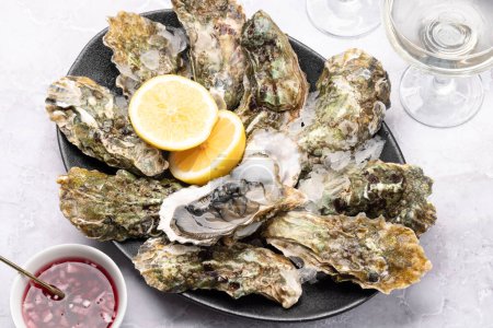 Photo for Fresh oysters with glasses of sparkling wine. Closeup - Royalty Free Image