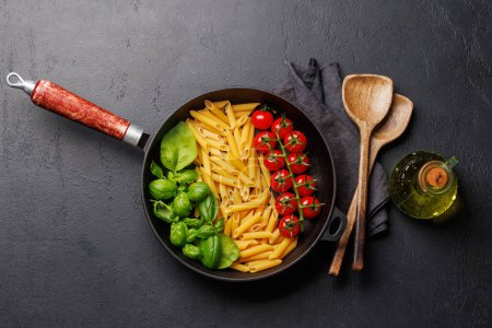 Téléchargez les photos : Une représentation vibrante du drapeau italien fait avec des pâtes, du basilic et des tomates, magnifiquement présenté dans une poêle. Pose plate - en image libre de droit