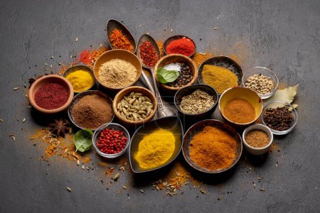 Photo for Various spices in bowls and spoons on stone table - Royalty Free Image