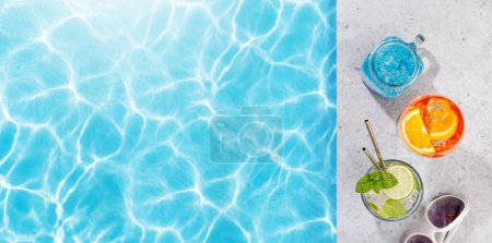 Téléchargez les photos : Cocktails rafraîchissants au bord de la piscine par une journée ensoleillée, les vacances d'été parfaites. Vue d'en haut avec espace pour votre texte - en image libre de droit