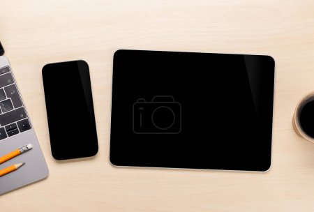 Foto de Smartphone de pantalla en blanco y tableta en un escritorio, perfecto para su maqueta de diseño - Imagen libre de derechos
