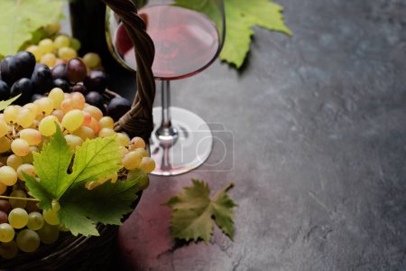 Foto de Vino tinto en copa, botella y uvas en cesta. Con espacio de copia - Imagen libre de derechos