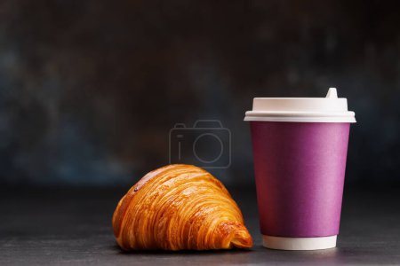 Téléchargez les photos : Café aromatique dans une tasse en papier associée à un croissant floconneux. Avec espace de copie - en image libre de droit