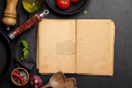 Photo for Top-down view of a kitchen table with ingredients, utensils, and an open cookbook with empty pages, perfect for creating a mockup for recipes or menus - Royalty Free Image