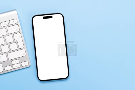 Foto de Smartphone de pantalla blanca en blanco en un escritorio, perfecto para su maqueta de diseño - Imagen libre de derechos