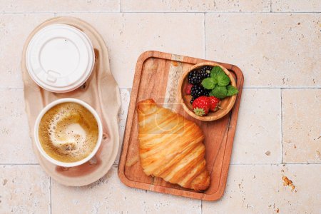 Foto de Café, croissant y bayas en la mesa de piedra. Puesta plana - Imagen libre de derechos