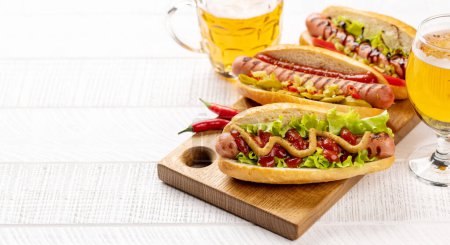 Foto de Various hot dog and beer. Homemade hotdogs on cutting board. With copy space - Imagen libre de derechos