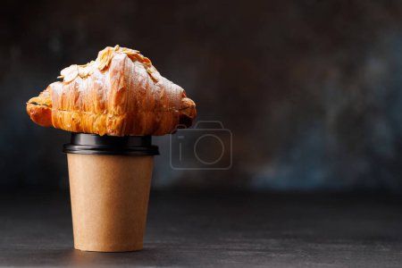 Photo for Aromatic coffee in a paper cup paired with a flaky croissant. With copy space - Royalty Free Image