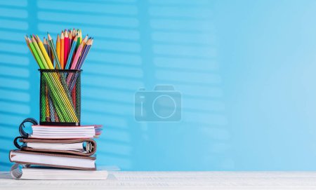 Foto de Un arreglo organizado de lápices de colores y bloc de notas en un escritorio de oficina, que ofrece un amplio espacio de copia para sus ideas creativas o texto - Imagen libre de derechos