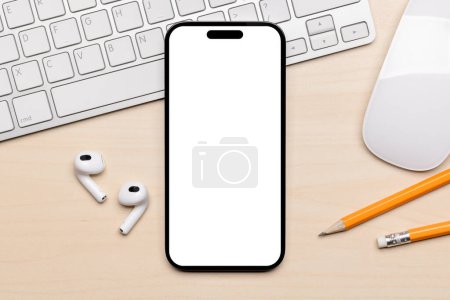 Foto de Smartphone de pantalla blanca en blanco en un escritorio, perfecto para su maqueta de diseño - Imagen libre de derechos