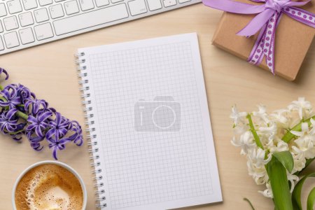 Téléchargez les photos : Bureau avec un cadeau, fleurs, bloc-notes et clavier, vue sur le dessus et espace pour noter - en image libre de droit