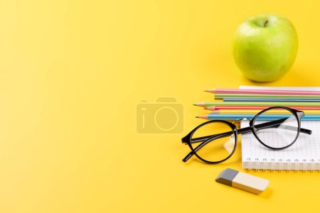 Téléchargez les photos : Fournitures scolaires, papeterie et boîte à lunch sur fond jaune. Éducation et nutrition. Avec espace vide - en image libre de droit