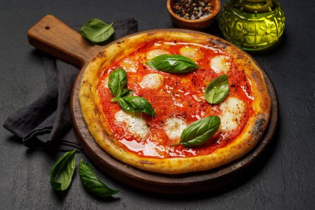 Photo for Homemade margarita pizza, topped with fresh tomatoes, mozzarella cheese, and aromatic basil leaves - Royalty Free Image