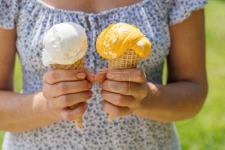 Foto de Manos de mujer sosteniendo refrescante helado en conos de gofre trata con un toque de sabor a limón picante - Imagen libre de derechos