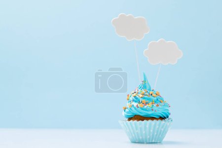 Photo for Blue cream cupcake with speech bubble decor on yellow background with copy space - Royalty Free Image