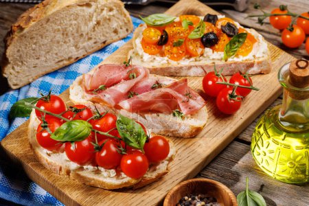 Photo for A delectable sandwich set of bruschetta adorned with juicy tomatoes, cheese, and savory prosciutto on outdoor garden table - Royalty Free Image