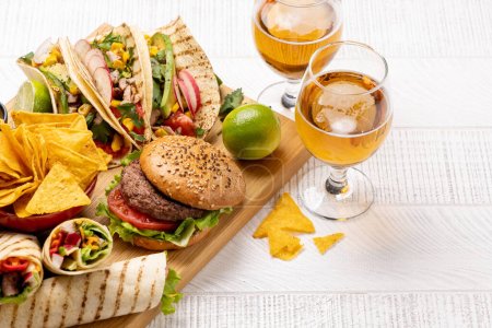 Foto de Comida mexicana con tacos, burritos, nachos, hamburguesas y cerveza. Con espacio de copia - Imagen libre de derechos