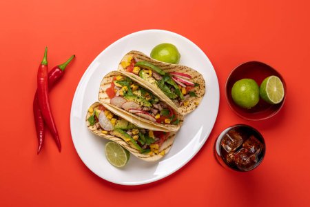 Téléchargez les photos : Nourriture mexicaine avec tacos à la viande et légumes grillés et cola. Pose plate sur rouge - en image libre de droit