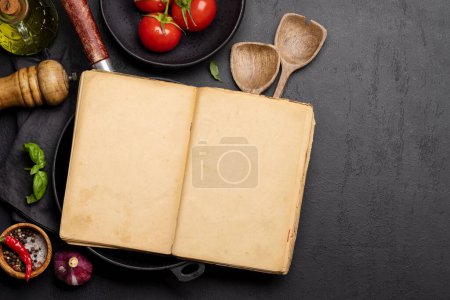 Téléchargez les photos : Vue du haut vers le bas d'une table de cuisine avec des ingrédients, des ustensiles et un livre de cuisine ouvert avec des pages vides, parfait pour créer une maquette pour les recettes ou les menus - en image libre de droit