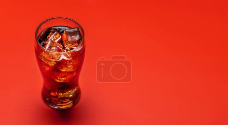 Téléchargez les photos : Refreshing glass of cola with ice. Over red background with copy space - en image libre de droit