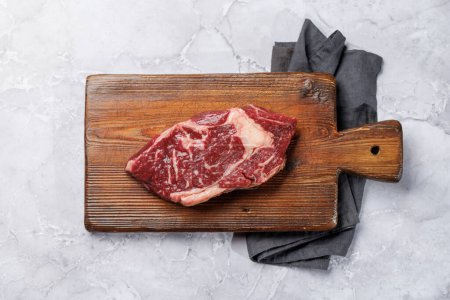 Téléchargez les photos : Bifteck de côtelette de bœuf cru, frais et prêt à cuire, promettant une expérience culinaire appétissante. Pose plate - en image libre de droit