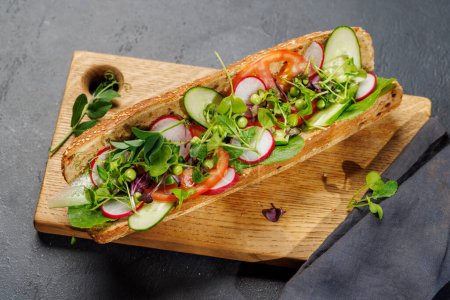 Téléchargez les photos : Délicieux sandwich végétarien farci dans une baguette fraîche, éclatant de saveur et d'ingrédients sains - en image libre de droit