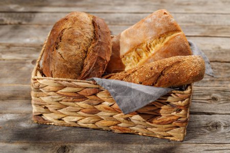 Téléchargez les photos : Variétés de pain variées dans un charmant panier, prêtes à être dégustées - en image libre de droit