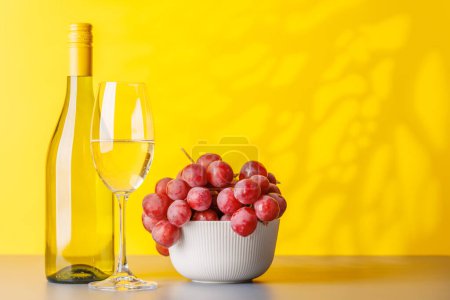 Téléchargez les photos : Bouteille de vin et raisins luxuriants, mettant en valeur l'art de la vinification. Avec espace de copie - en image libre de droit