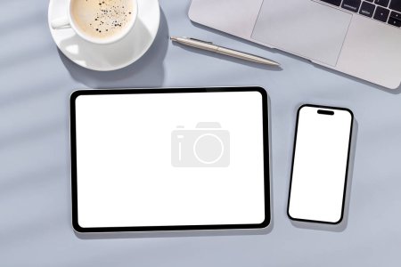 Téléchargez les photos : Smartphone à écran blanc vierge et tablette sur un bureau, parfait pour votre maquette de design - en image libre de droit
