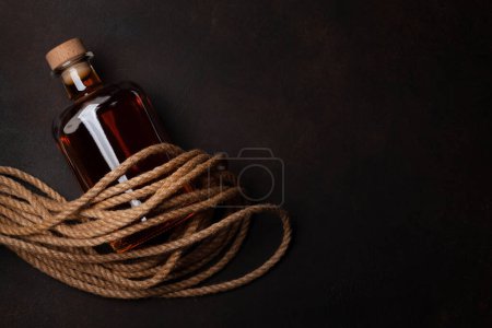 Téléchargez les photos : Bouteille avec rhum, cognac ou whisky. Vue du dessus plat avec espace de copie - en image libre de droit
