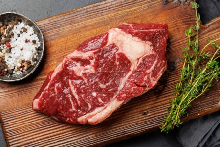 Raw beef ribeye steak, fresh and ready for cooking, promising a mouthwatering culinary experience. Flat lay