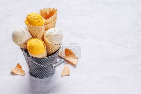Foto de Helado de limón en deliciosos conos de gofres, una delicia para todos los gustos. Sobre fondo de piedra con espacio de copia - Imagen libre de derechos