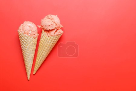Photo for Watermelon ice cream in delightful waffle cones. Over red background with copy space, flat lay - Royalty Free Image