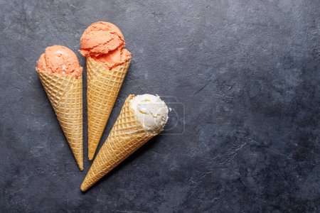 Foto de Surtido de sabores de helado en deliciosos conos de gofres, un regalo para todos los papilas gustativas. Sobre fondo de piedra con espacio de copia. Puesta plana - Imagen libre de derechos