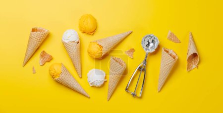 Téléchargez les photos : Saveurs variées de crème glacée dans de délicieux cônes de gaufres, un régal pour tous les papilles. Sur fond jaune, plat - en image libre de droit