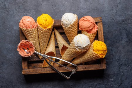 Téléchargez les photos : Saveurs variées de crème glacée dans de délicieux cônes de gaufres, un régal pour tous les papilles. Sur fond de pierre. Pose plate - en image libre de droit