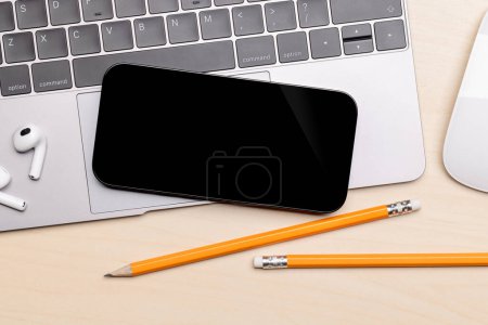 Photo for Blank black screen smartphone on a desk, perfect for your design mockup - Royalty Free Image
